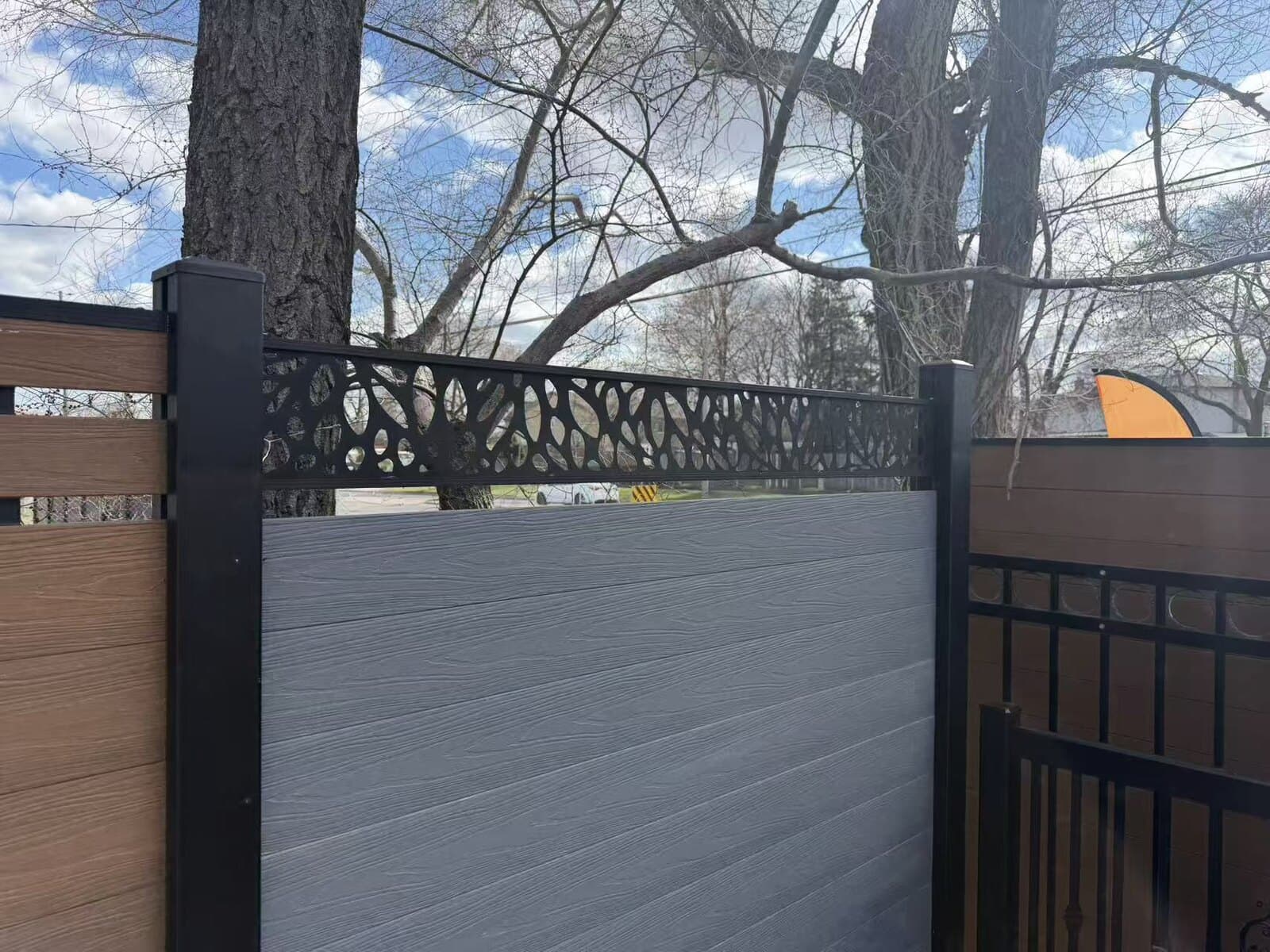 WPC composite fence topped with a laser-cut decorative panel