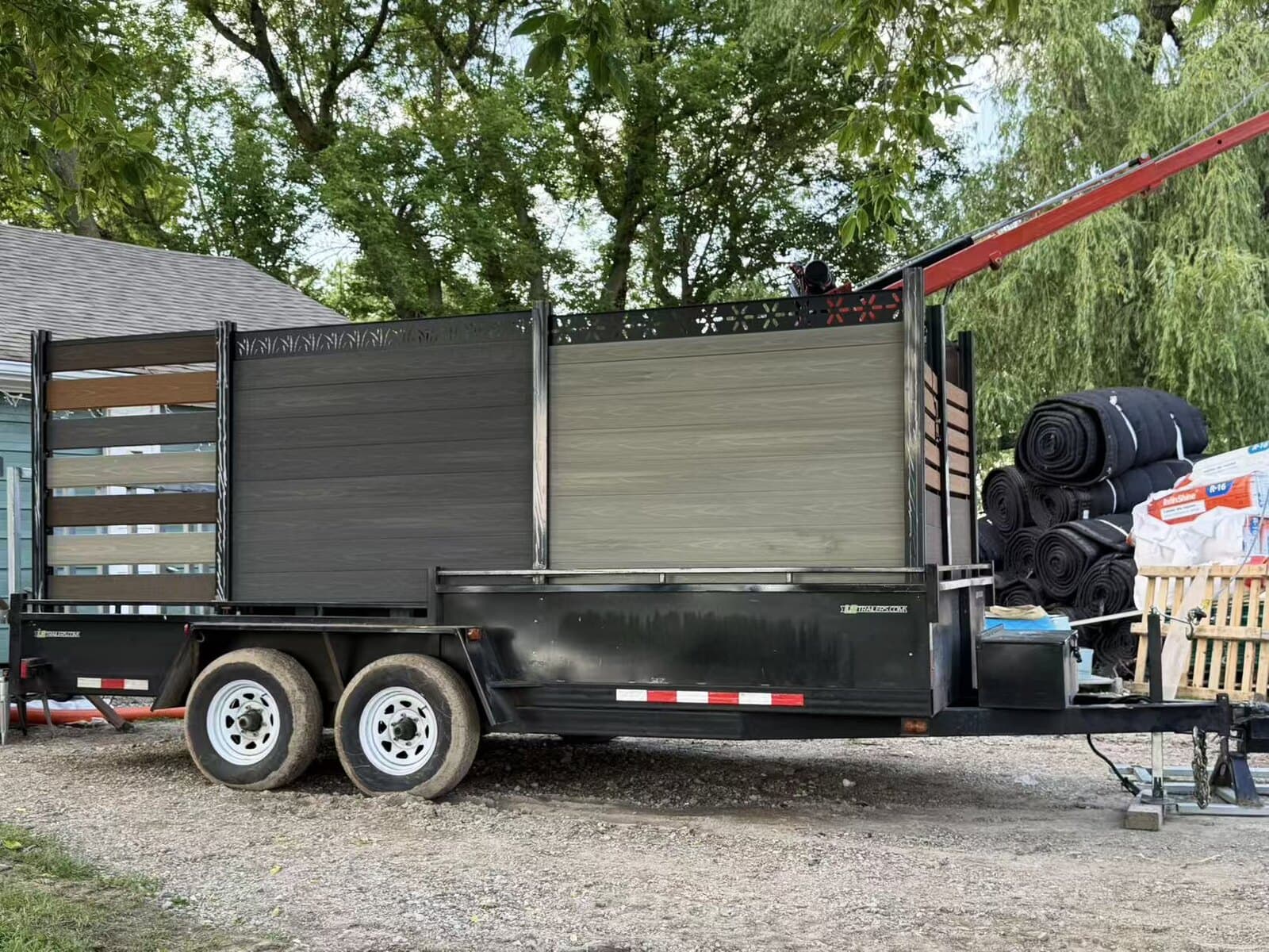 Tandem-axle dump trailer loaded with composite fence panels