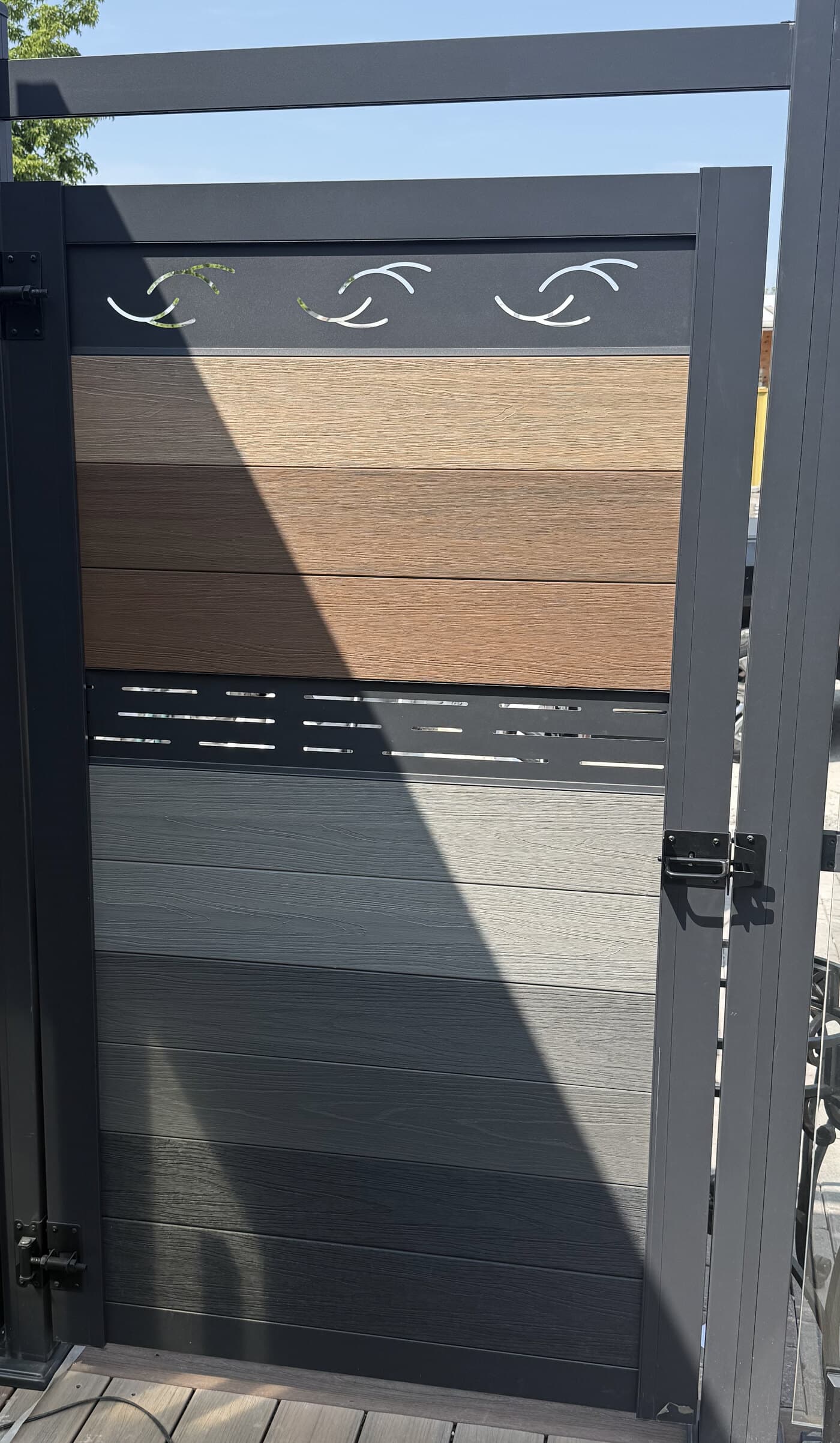 WPC gate door with decorative laser-cut top rail in an aluminum alloy frame