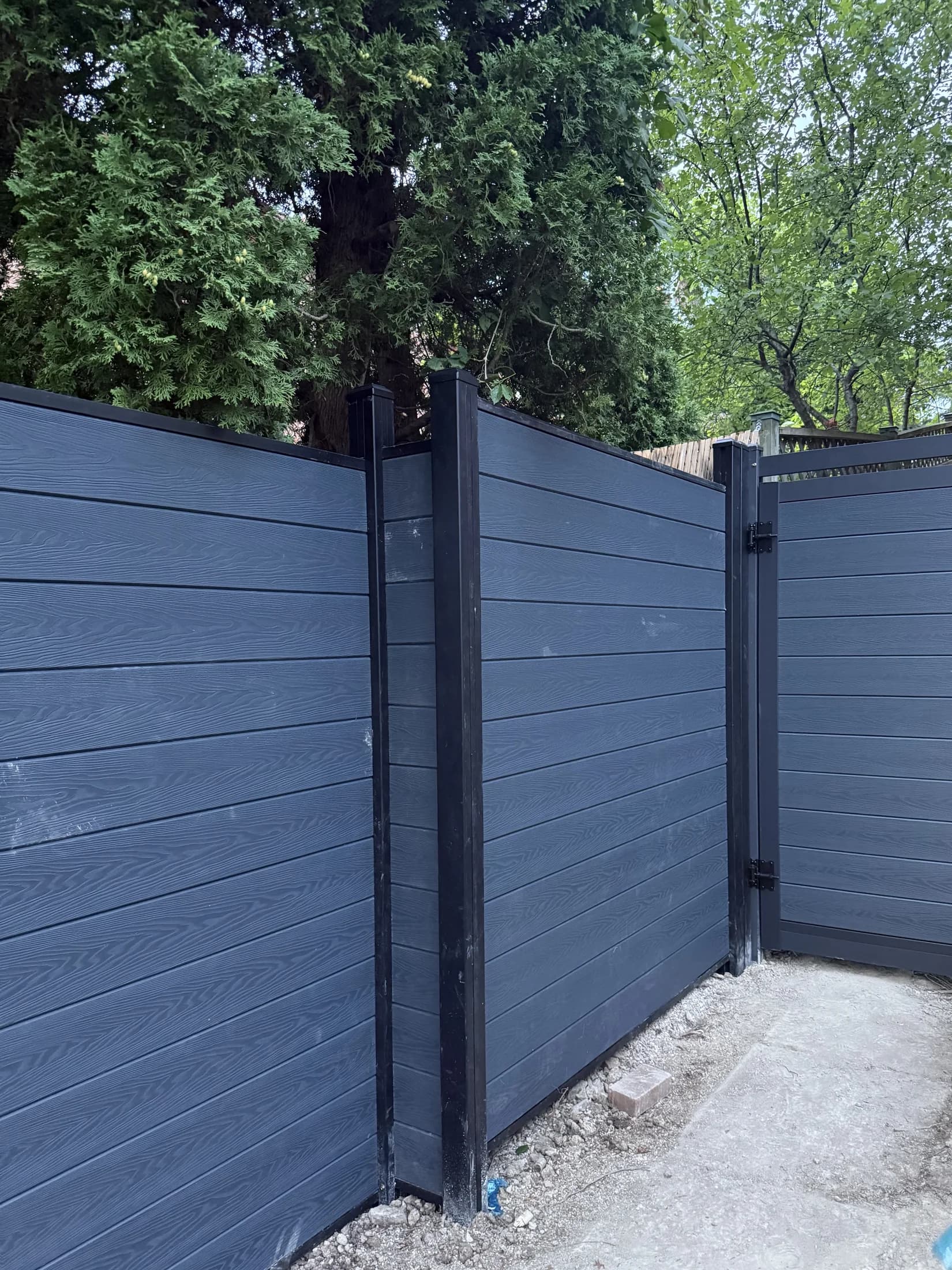 Charcoal WPC side-yard gate aligned with matching privacy fence panels